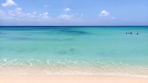 A beach with clear turquoise water and a sandy shore. - Sasaki Apartments (Noord)