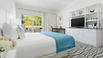 A hotel room with a bed, a desk, a television, and a bookshelf.