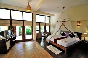 Quarto espaçoso com uma cama grande, televisão e escrivaninha.