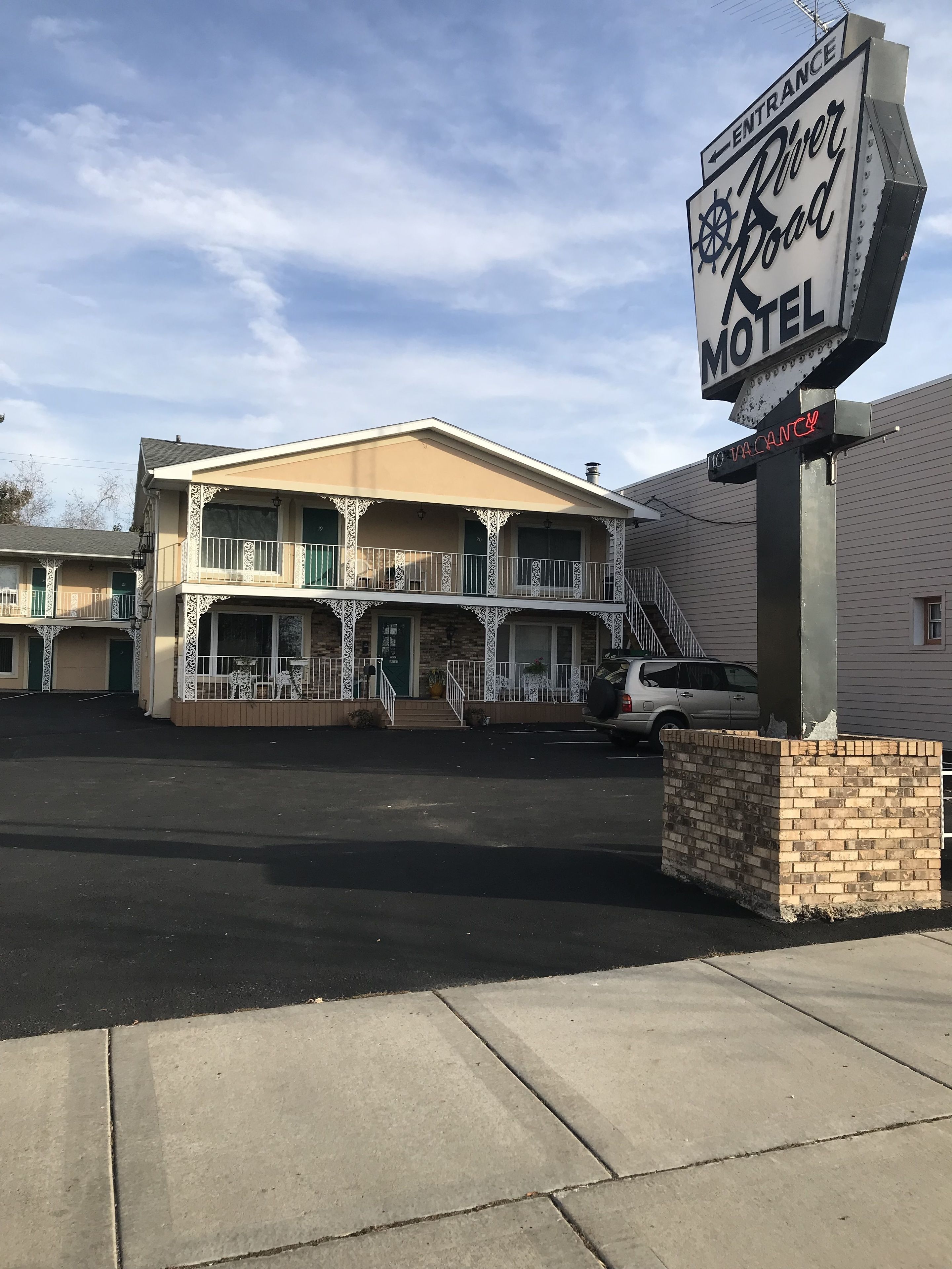 A motel with a sign indicating 'River Road Motel' and 'No Vacancy'.