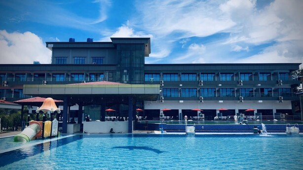 A hotel with a large swimming pool, outdoor seating, and a modern architectural design. - Excel River View Hotel (Thanlyin)