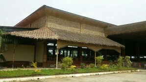 A building with a thatched roof and a covered entrance area. - Excel River View Hotel (Thanlyin)