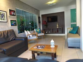 A modern living room with a sofa, armchairs, a coffee table, and a TV.