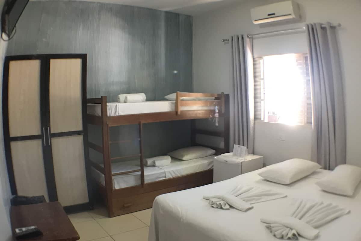 A room with bunk beds, a desk, and a bedside table with toiletries.