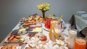Una mesa de buffet con diversos alimentos, como pasteles, frutas y bebidas.