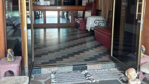 A room with a tiled floor, a sofa, a table, and a decorative statue. - Huahin Euro City Hotel (Hua Hin)