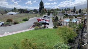 A residential area with a parking lot, a swimming pool, and a view of mountains in the background.