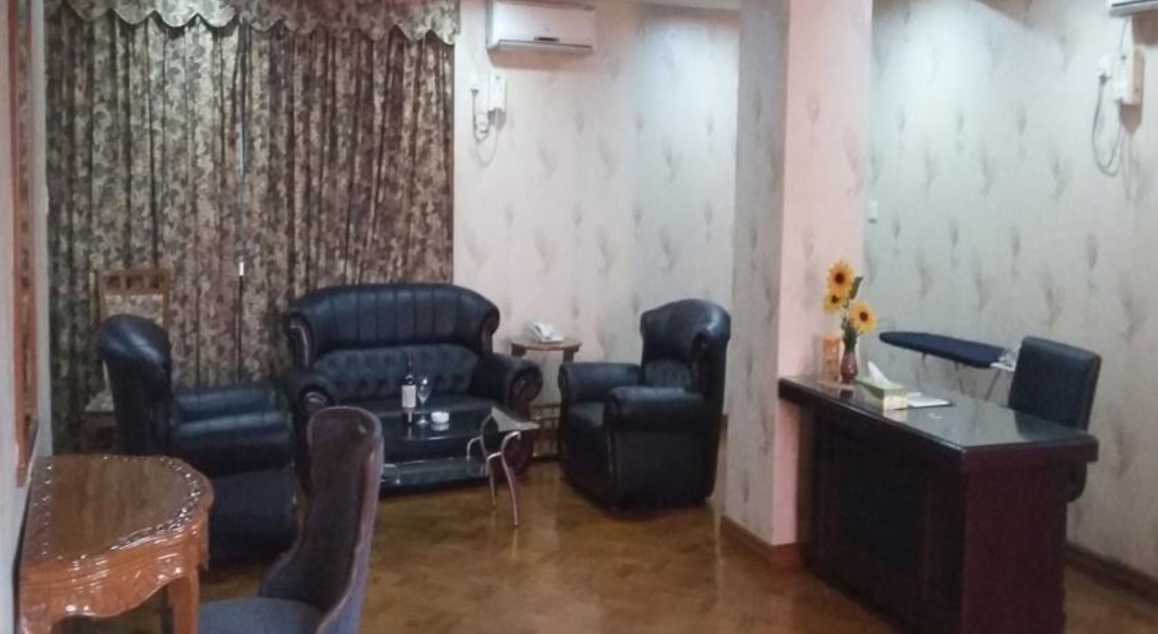 A living room with a sofa, two armchairs, a coffee table, and a dining table with chairs.