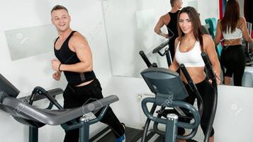 Un gimnasio con cintas de correr y equipo de ejercicio.
