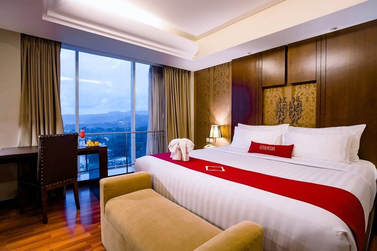 Une chambre d’hôtel avec un grand lit, un bureau, une chaise et une vue sur la ville.