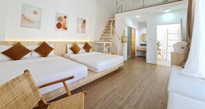 A hotel room with two beds, a wooden floor, a staircase, and a kitchen area. - Sawasdee Coco (Rayong)