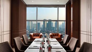 A conference room with a city view, leather chairs, a long table, and water bottles.