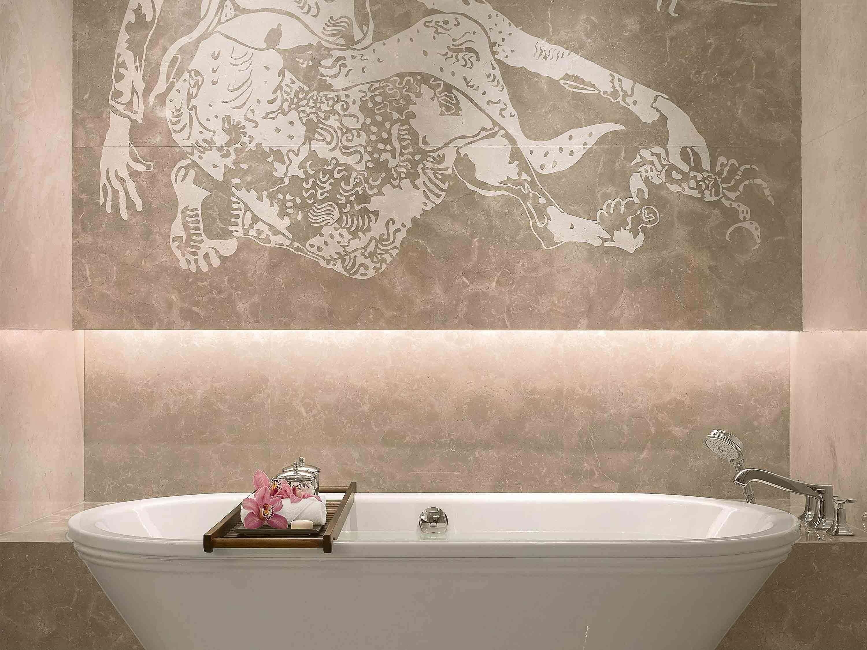 Un baño con una bañera independiente, un perchero y un mural decorativo.