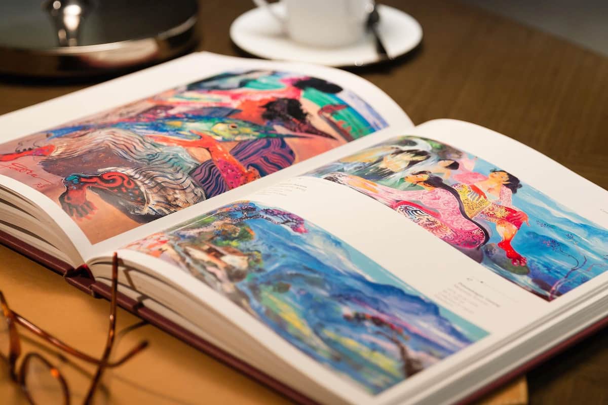 An open book with colorful illustrations on a wooden table.