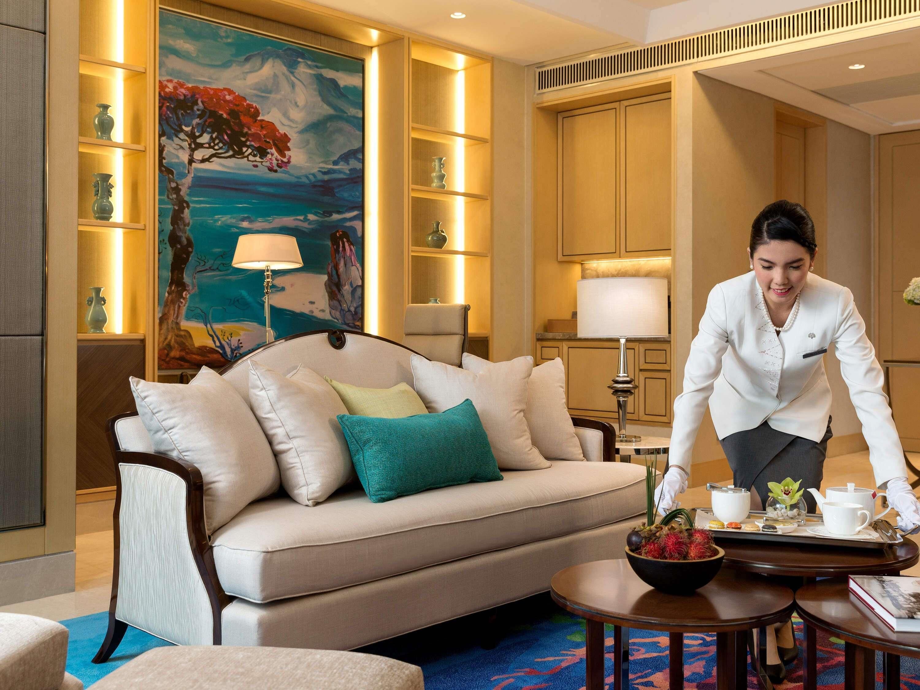 A well-lit living room with a sofa, a painting, and a tray with tea set.