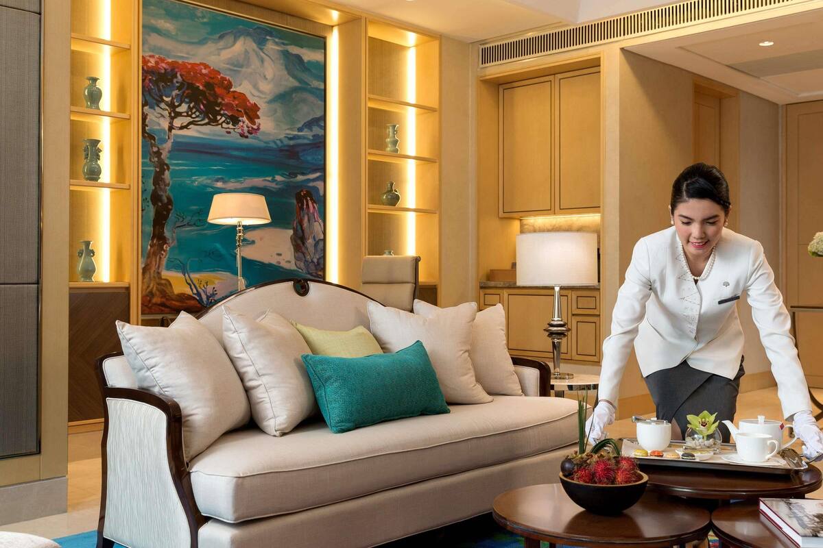 A well-lit living room with a sofa, a painting, and a tray with tea set.