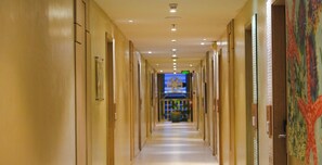 A hotel hallway with doors, a security camera, and a digital clock on the wall. - Azalea Hotels & Residences Boracay (Boracay Island)