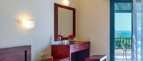 A hotel room with two beds, a vanity with a mirror, and a balcony with a view.