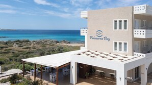 A building with a sign reading 'Falasarna Bay' and a patio area with tables and chairs. - Falasarna Bay (Kissamos)