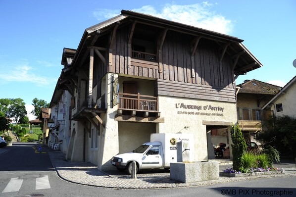 A traditional wooden building with a sign reading "L'Aurège d'Antry."
