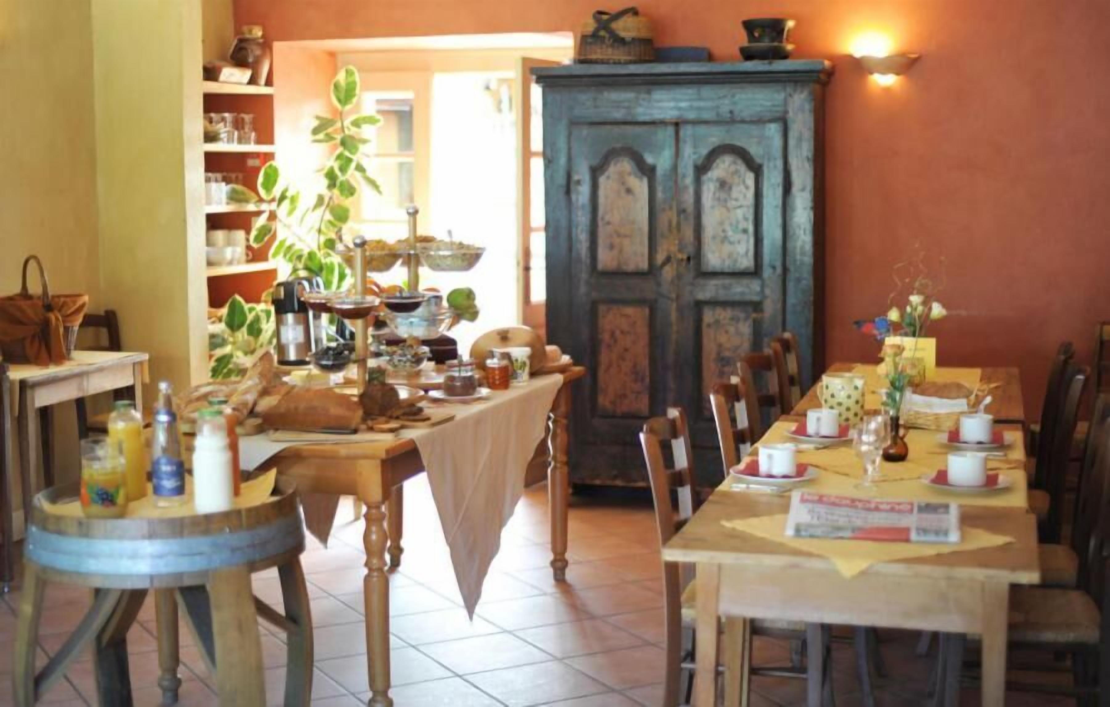 A cozy dining area with wooden tables and chairs, a bookshelf, and a cabinet.