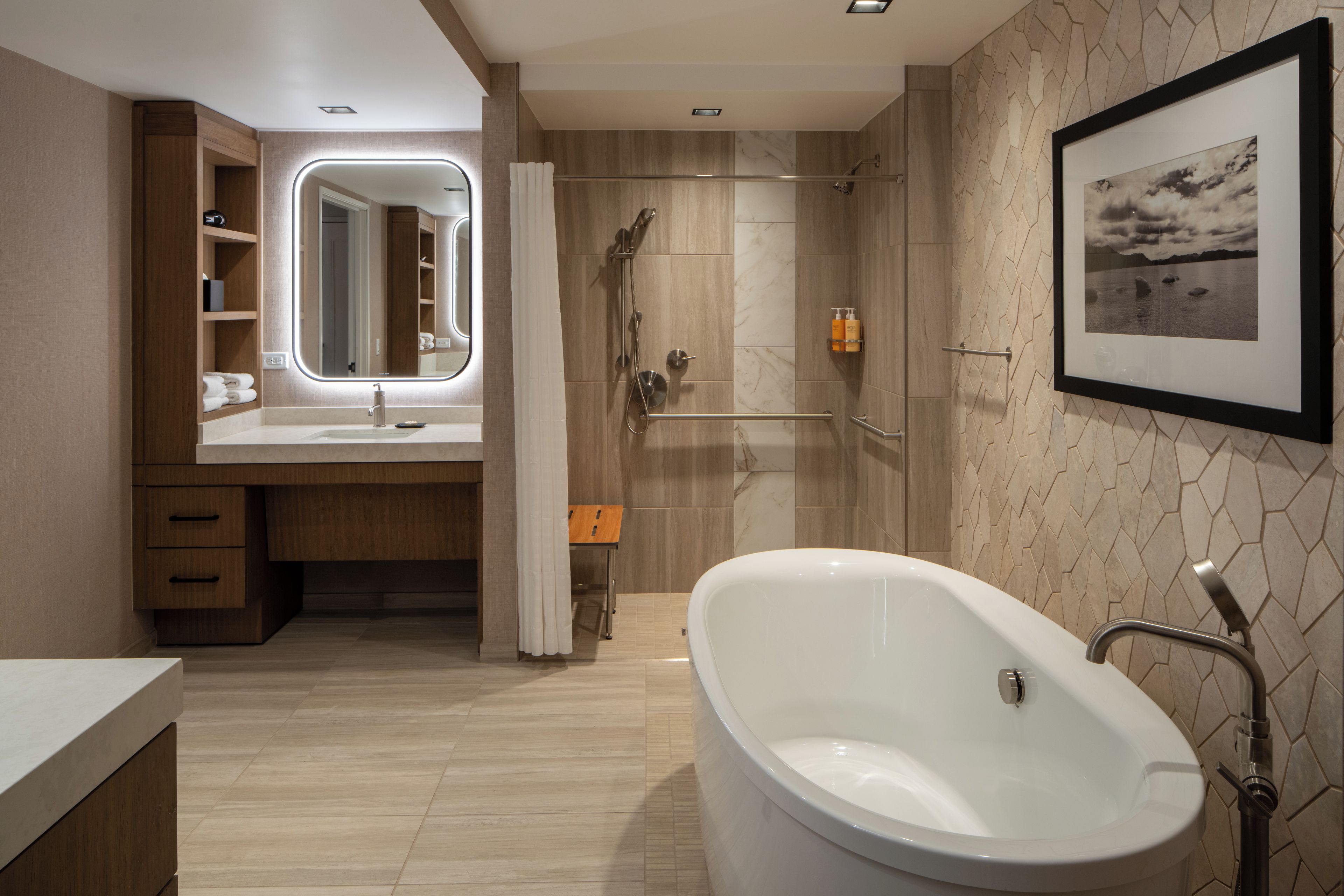 Un baño moderno con una bañera independiente, un tocador con espejo y una zona de ducha.