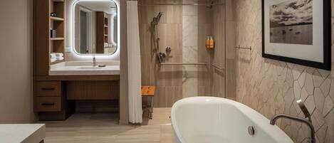 A modern bathroom with a freestanding bathtub, a vanity with a mirror, and a shower area.
