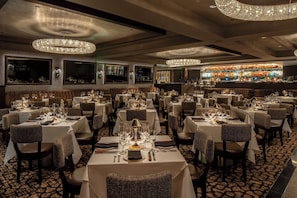 A restaurant with multiple tables, chairs, and a bar area.