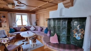 A cozy wooden interior with a sofa set, a round table, and a decorative cabinet. -  Hotel Sonnleiten (Reit im Winkl)