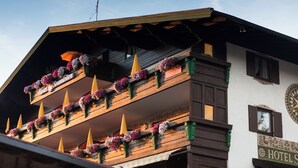 A hotel with a wooden facade, balconies with flower boxes, and a sign indicating it is a hotel. -  Hotel Sonnleiten (Reit im Winkl)