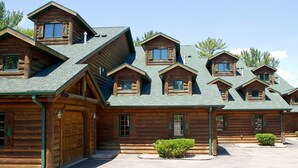 Un edificio in stile baita di legno con diversi tetti a punta e ampie finestre.