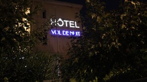 A hotel sign with the name "HOTEL VOL DENJIT" illuminated in blue. - Hotel Vol de Nuit (Toulouse)