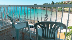 A balcony with white railings overlooking a beach. - Hotel Atalaya II (Sanxenxo)
