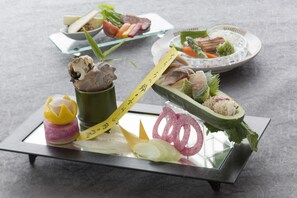 Un assortiment de sushis et de sashimis présentés sur un plateau en verre.