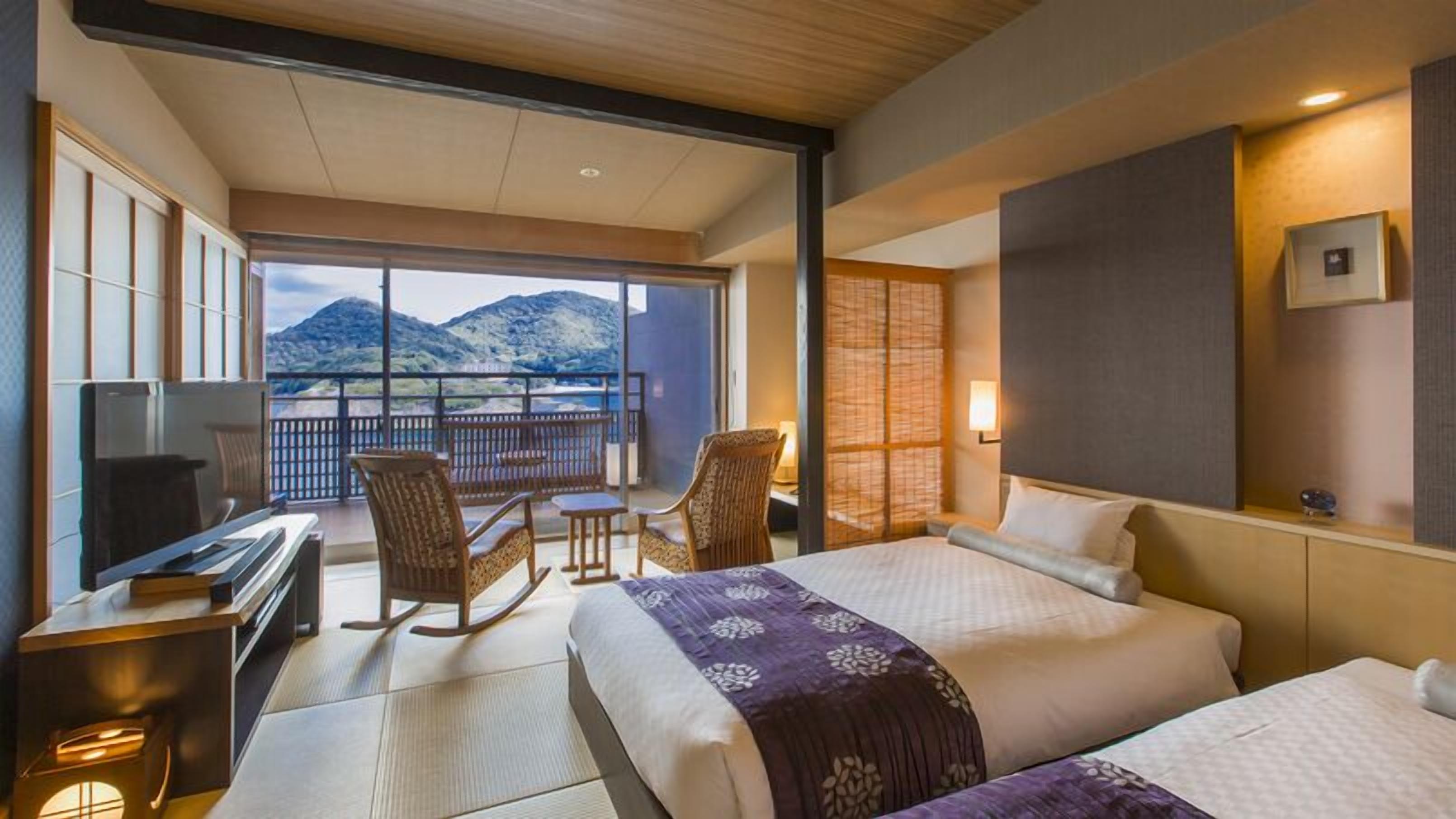 Une chambre d’hôtel avec un balcon, un lit, un bureau et une chaise.
