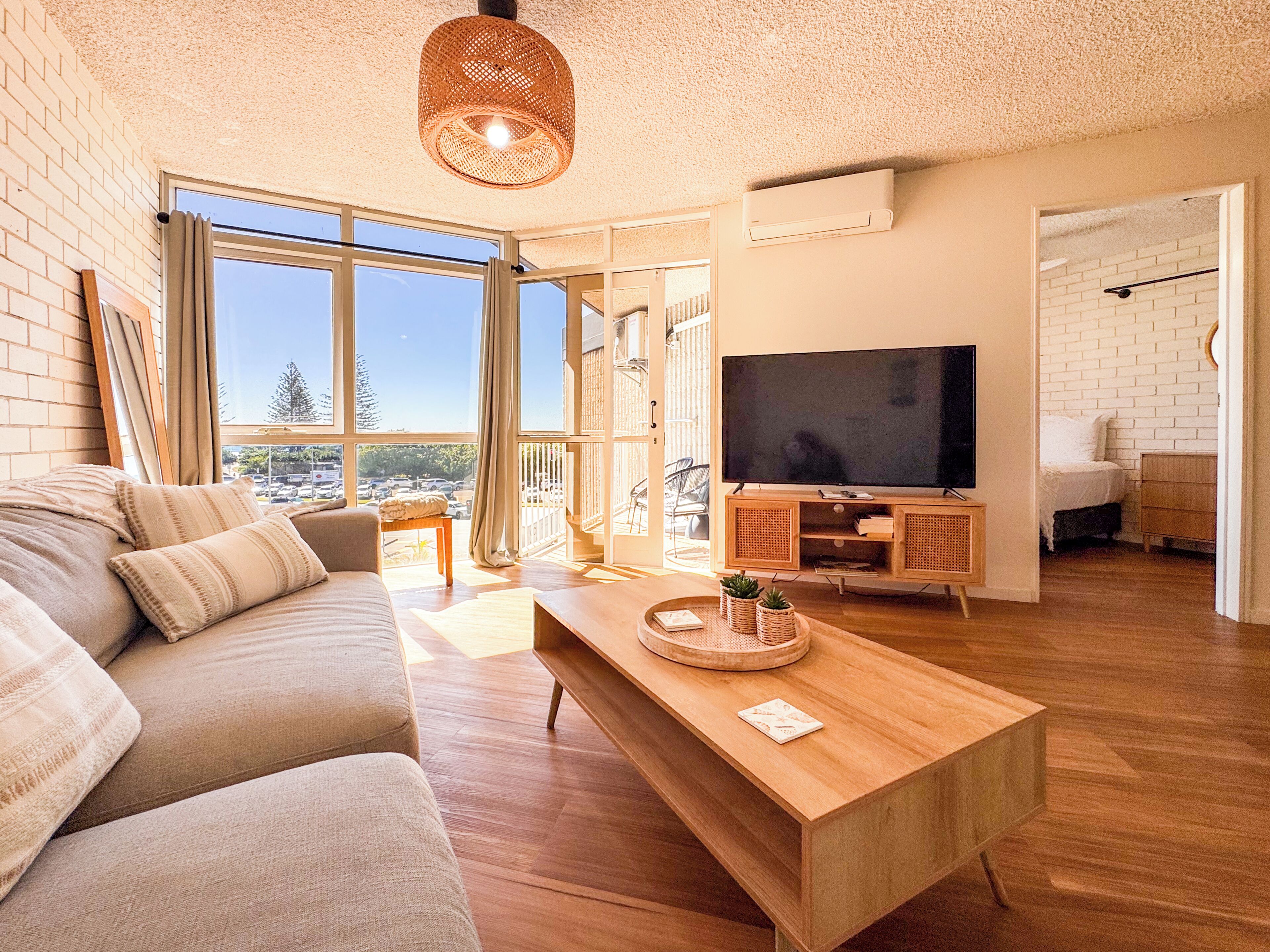 A modern living room with a sofa, coffee table, and a flat-screen TV.
