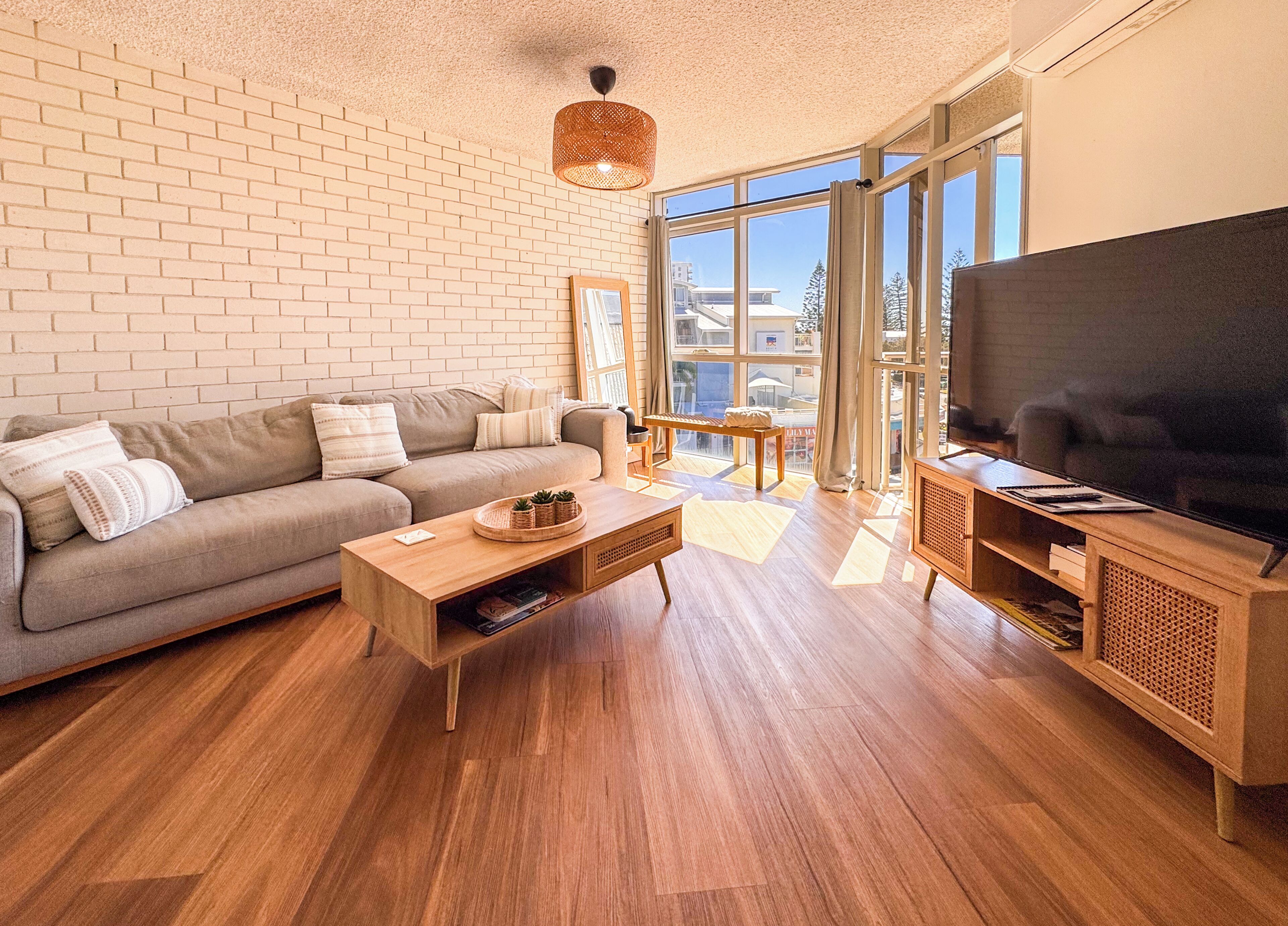 A modern living room with a sofa, coffee table, and TV stand.