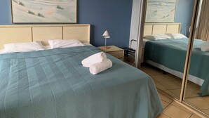 A hotel room with two beds, a large mirror, and artwork on the walls. - Northpoint Holiday Apartments (Alexandra Headland)