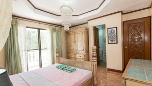 Un dormitorio con cama, lámpara de araña, armario y puerta.