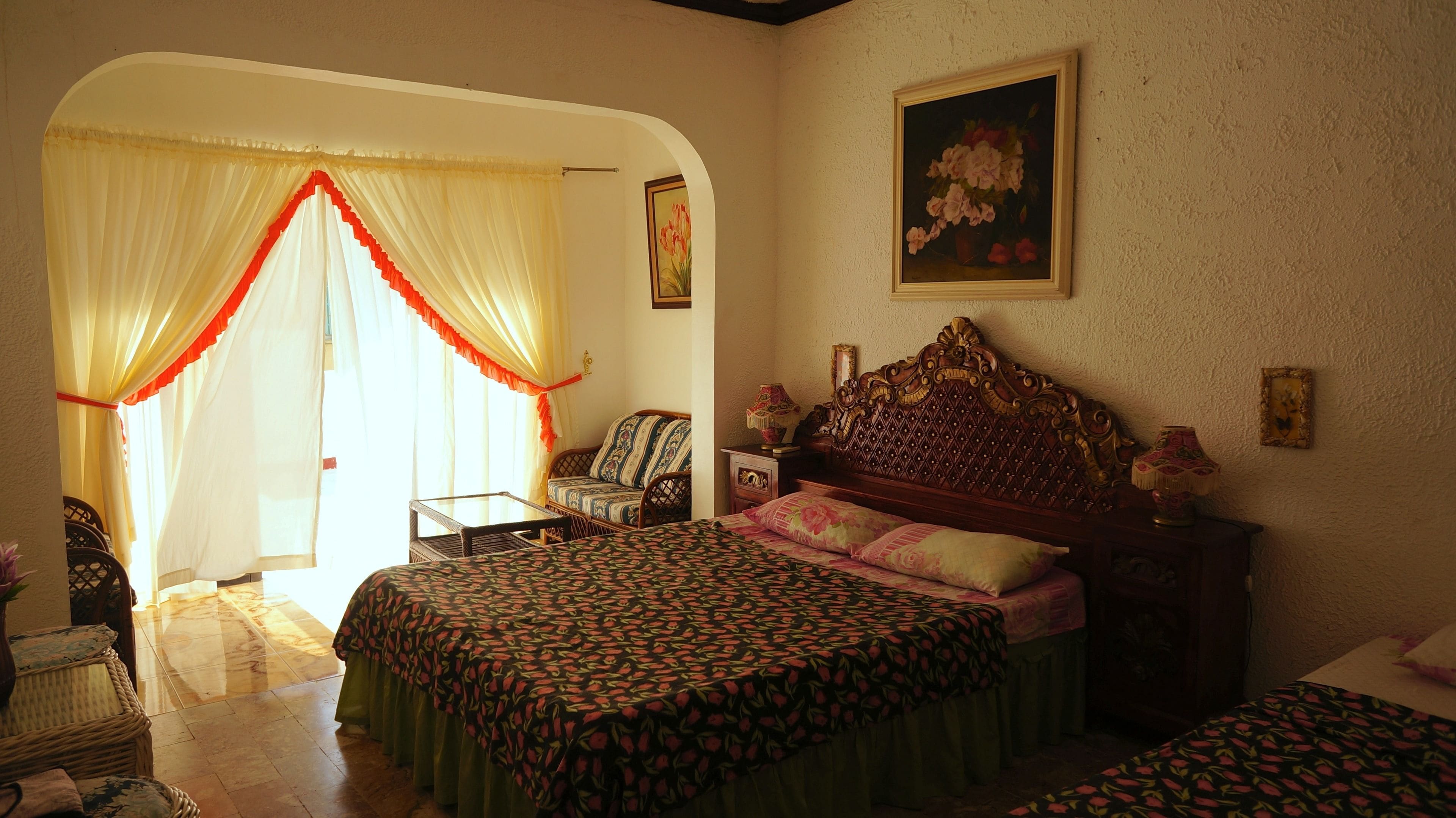 Un dormitorio con cama, una silla, una mesa y un cuadro en la pared.