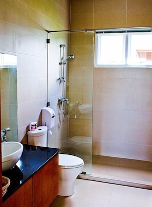 A modern bathroom with a glass-enclosed shower, a sink, and a toilet. - Black Mountain Resort (Hua Hin)