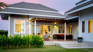 A modern house with a covered patio, a lawn, and a red fire extinguisher. - Black Mountain Resort (Hua Hin)