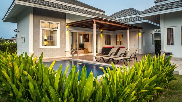 A modern house with a swimming pool, covered patio, and lush greenery. - Black Mountain Resort (Hua Hin)