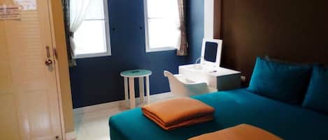 Een kamer met een bed, een bureau, een stoel en een klein tafeltje.