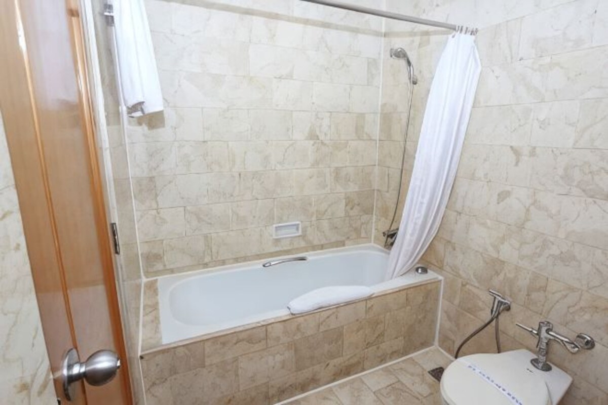 Un baño con bañera, ducha e inodoro.