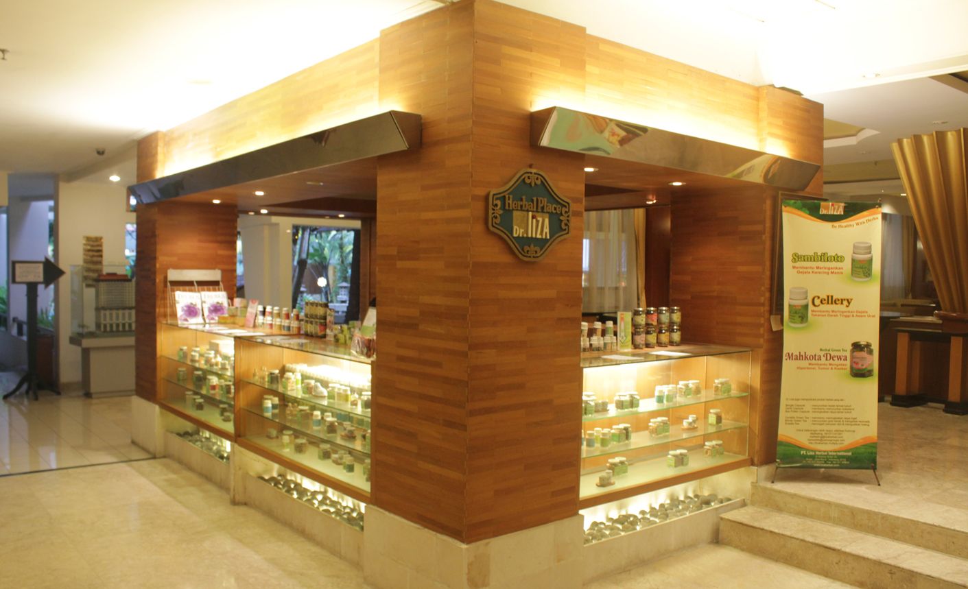 A wooden kiosk with glass display shelves containing various products.