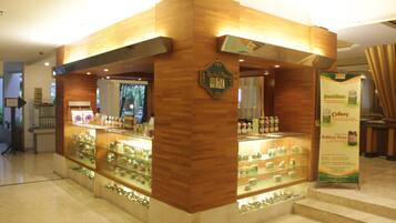 A wooden kiosk with glass display shelves containing various products.