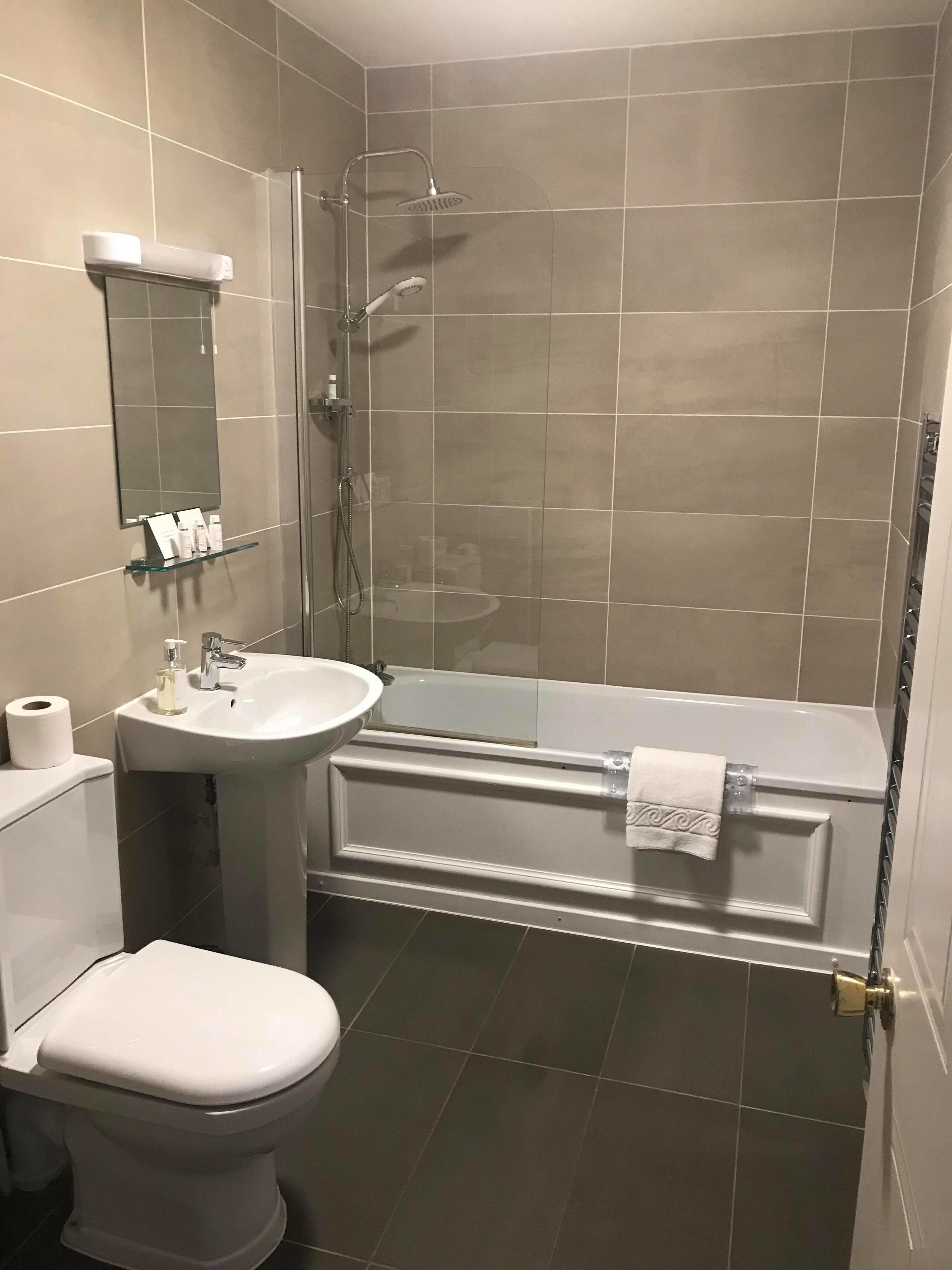 A modern bathroom with a toilet, sink, and bathtub.