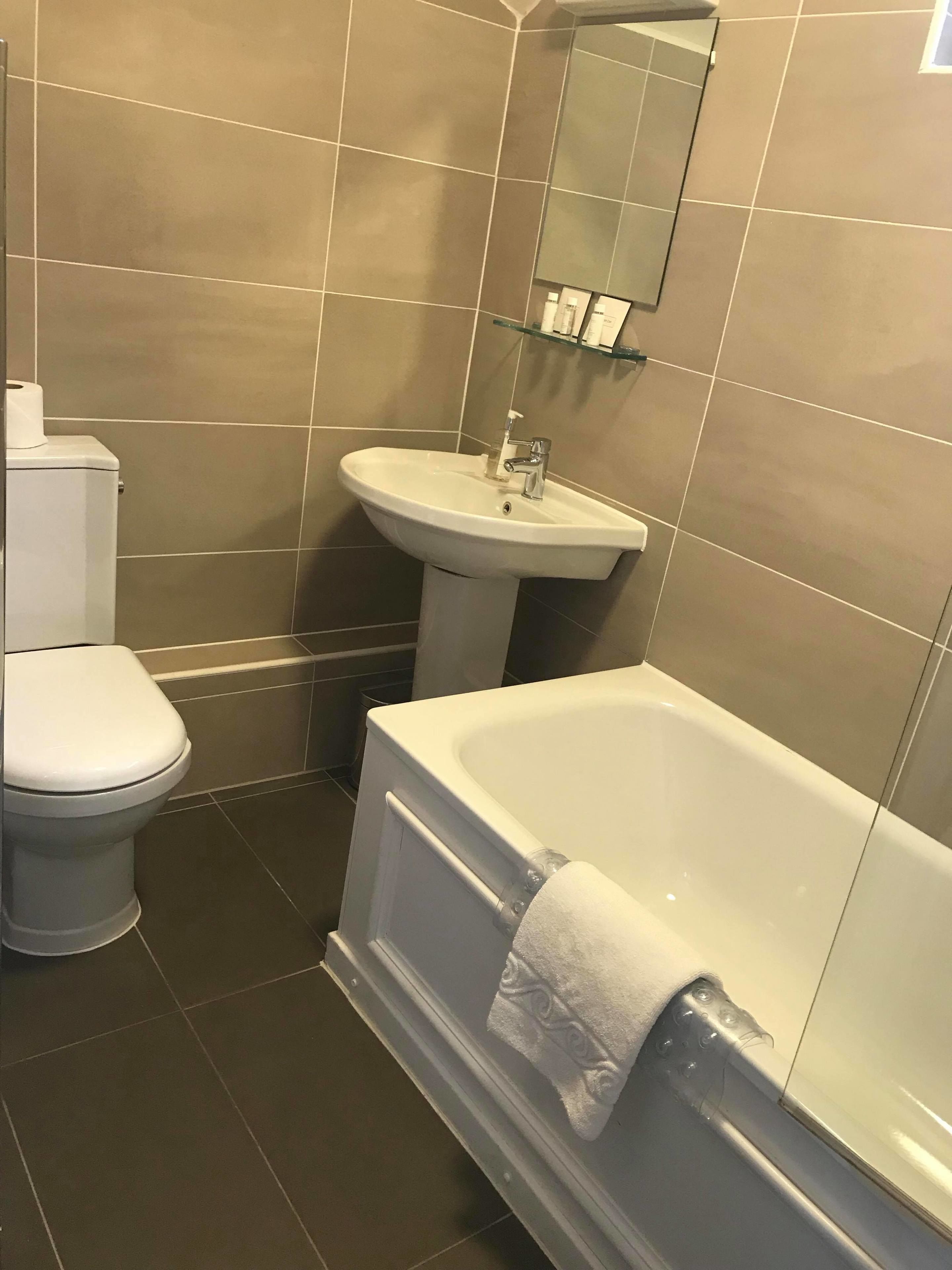 A bathroom with a toilet, sink, and bathtub.