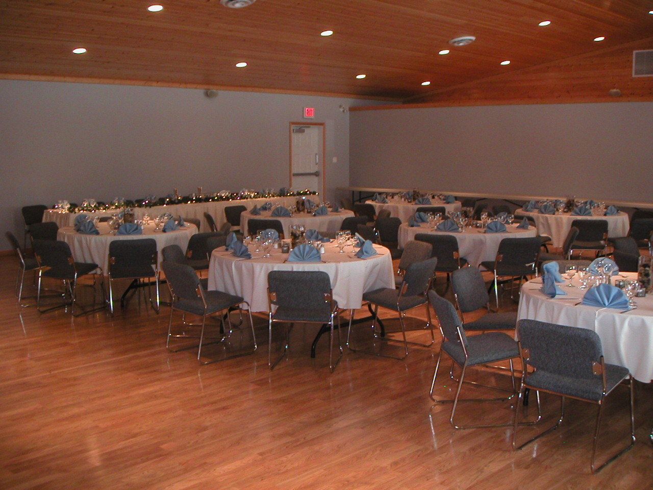 A banquet hall with round tables set for dining, equipped with chairs and table settings.